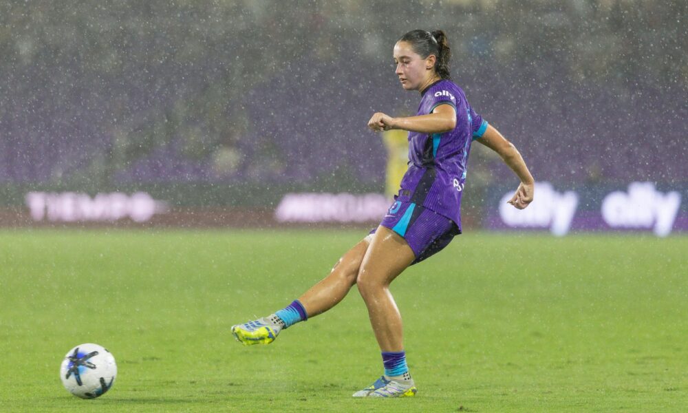 Image of Ally Lemos playing the ball in heavy rain against North Carolina.