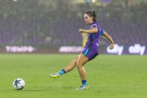 Image of Ally Lemos playing the ball in heavy rain against North Carolina.