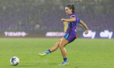 Image of Ally Lemos playing the ball in heavy rain against North Carolina.