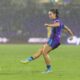 Image of Ally Lemos playing the ball in heavy rain against North Carolina.