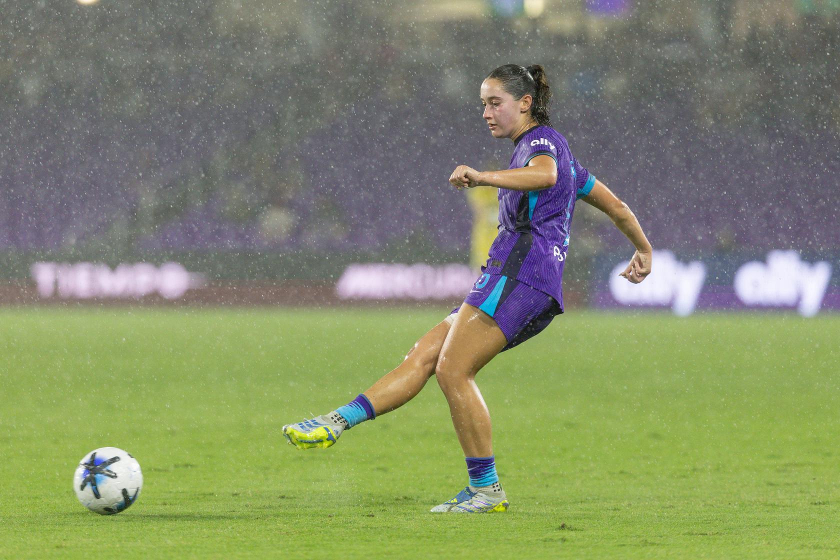 Image of Ally Lemos playing the ball in heavy rain against North Carolina.