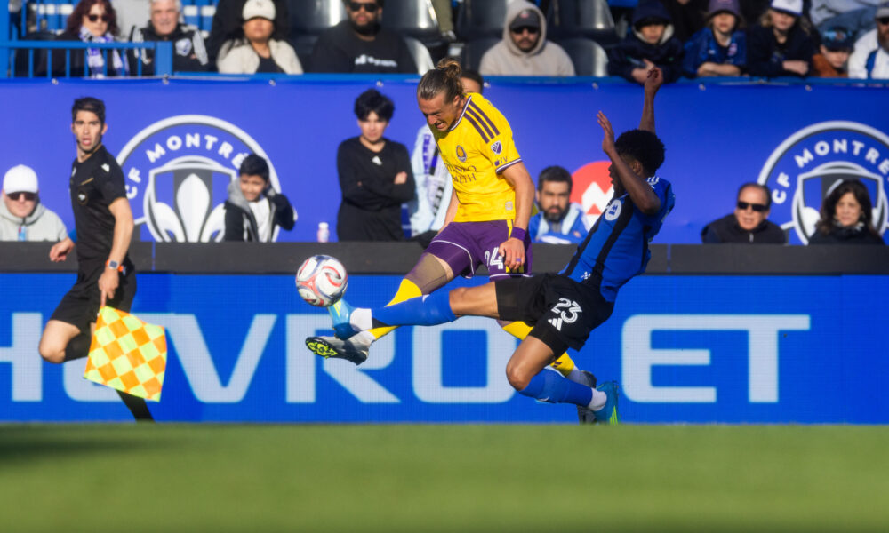 Image of Griffin Dorsey trying to send the ball upfield against a Montreal defender.