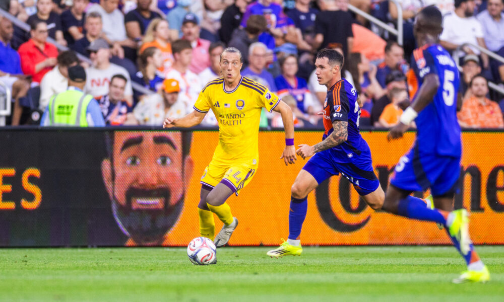 Image of Griffin Dorsey dribbling up the side past two FC Cincinnati defenders.