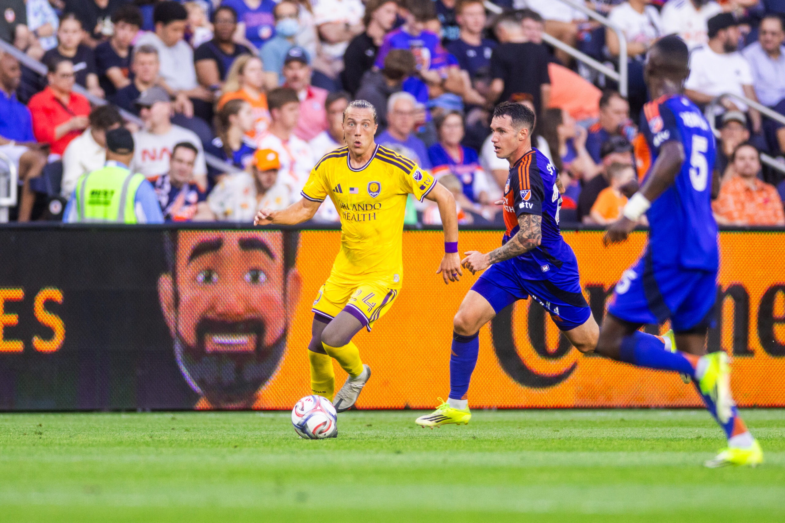 Image of Griffin Dorsey dribbling up the side past two FC Cincinnati defenders.