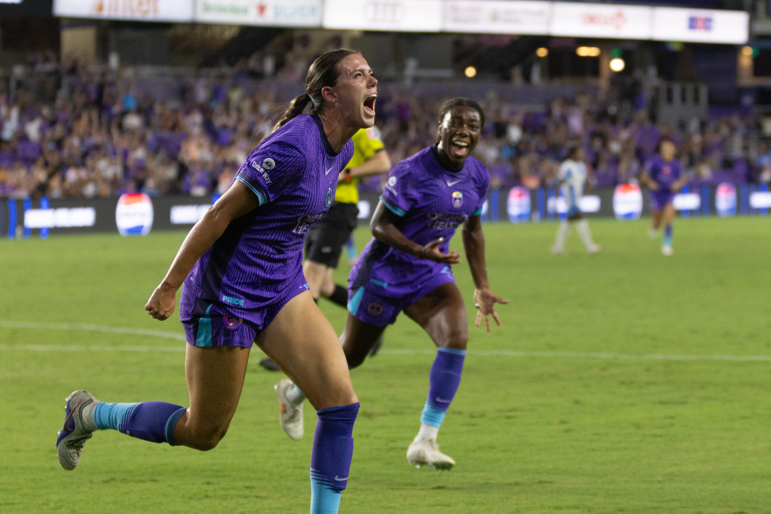 Image of Julie Doyle celebrating her winning goal against Chicago as Nicole Payne cheers her on.