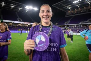 Image of Hannah Anderson posing with her Pride Player of the Match chain.