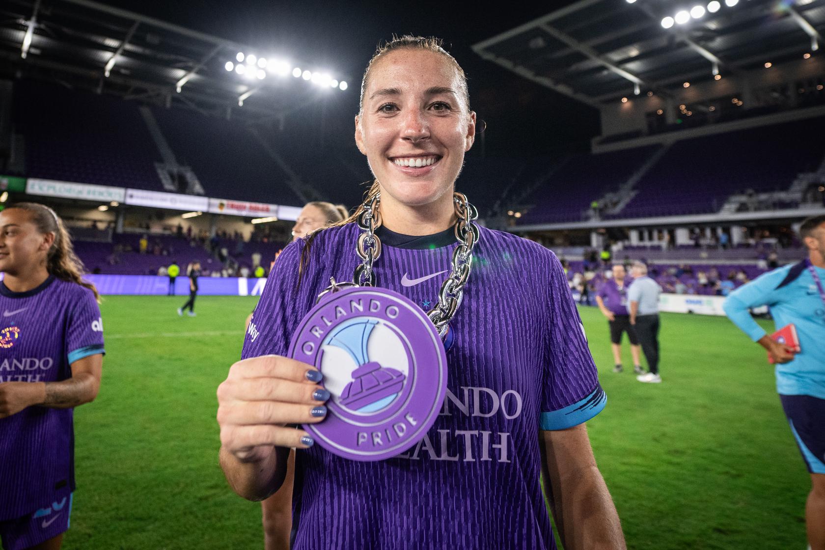 Image of Hannah Anderson posing with her Pride Player of the Match chain.