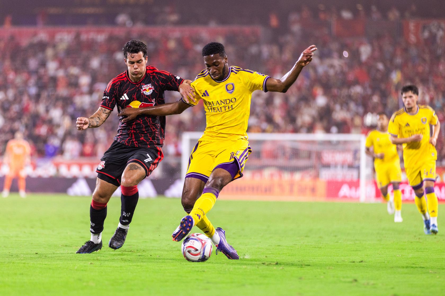 Image of Tyrese Spicer fending off a New York Red Bulls defender.