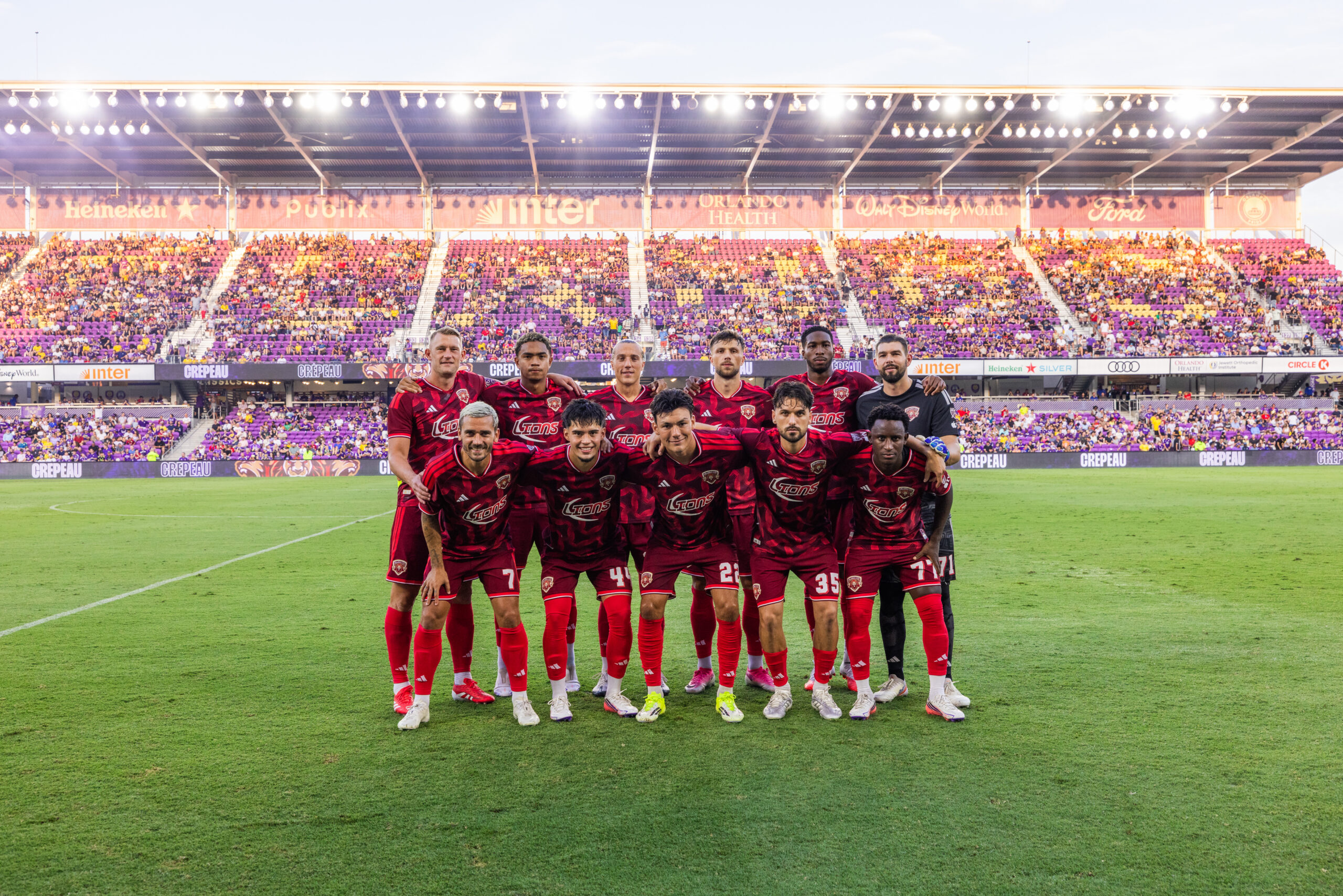 Image of Orlando City's starters pose for a pregame photo wearing their Archive Collection third kits.