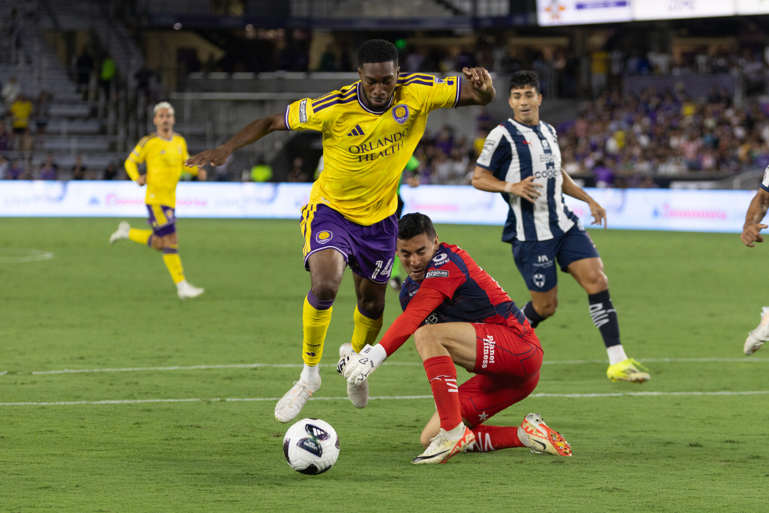 Image of Tyrese Spicer being fouled by Monterrey goalkeeper Luis Cardenas.
